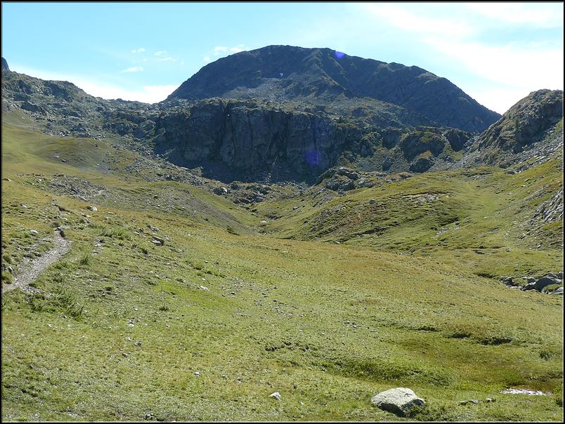 Accès aux lacs de Morgon en contournant la barre rocheuse par la gauche. Au fond le Pas de Morgon (2714 m) et la Tête des Mourres (2790 m)